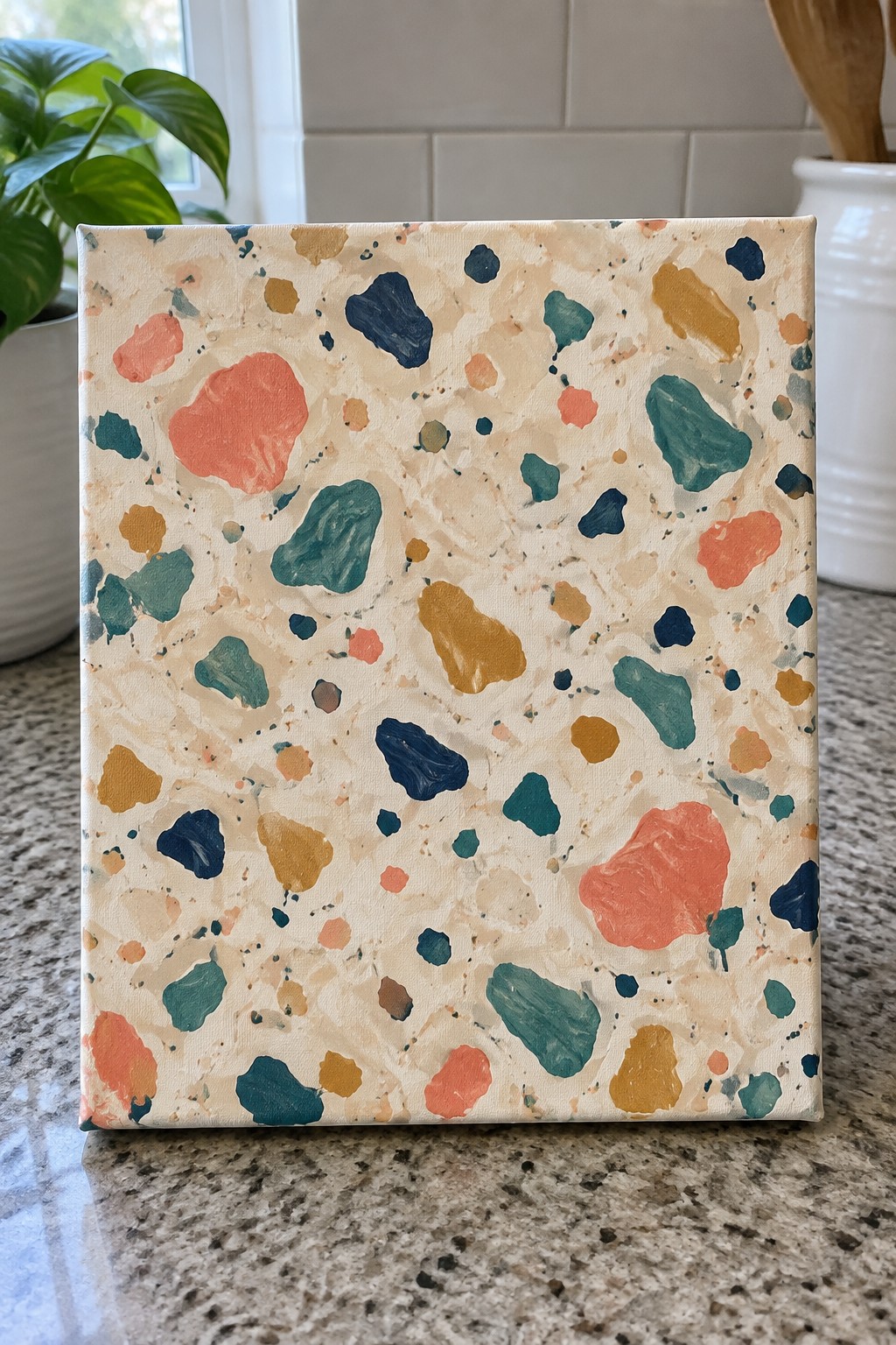 Abstract terrazzo painting with coral, teal, navy, and yellow blobs on beige canvas