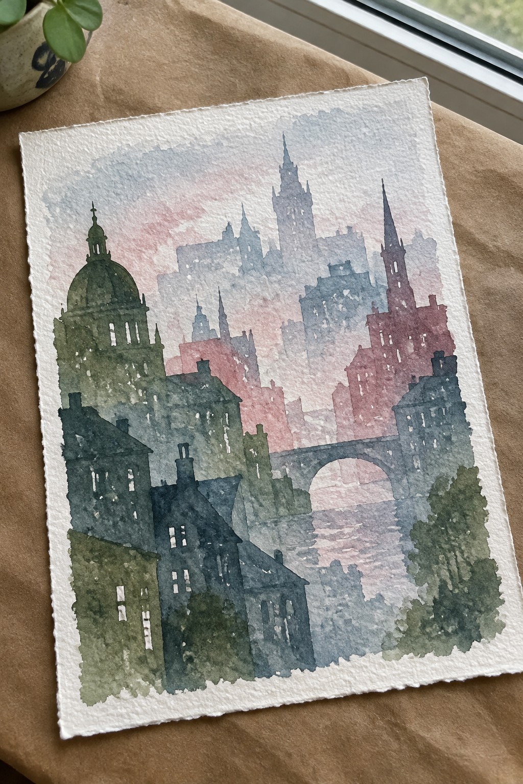 Watercolor cityscape with towers, dome, arched bridge in muted greens, blues, and pinks on paper