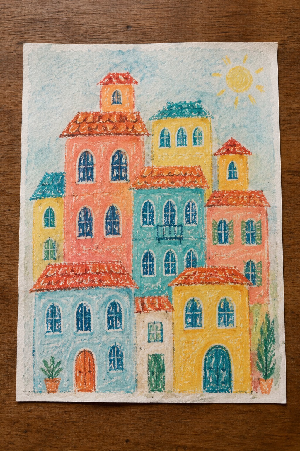 Colorful pastel drawing of vibrant buildings with red roofs under a yellow sun