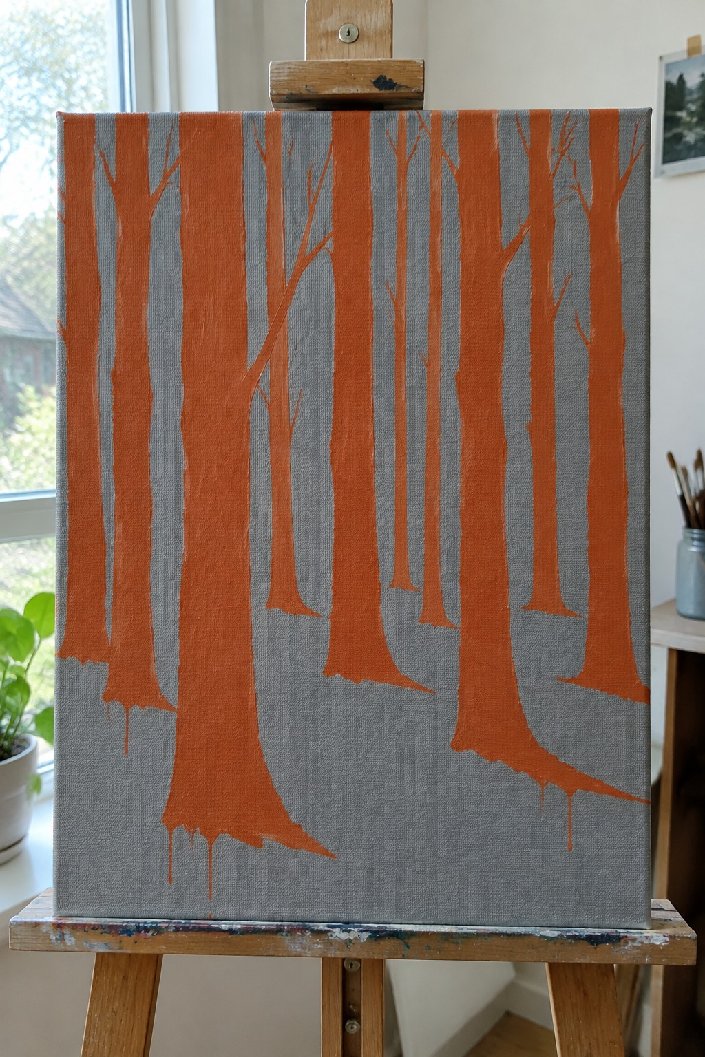 Orange tree trunks with branches on gray canvas atop wooden easel with drips