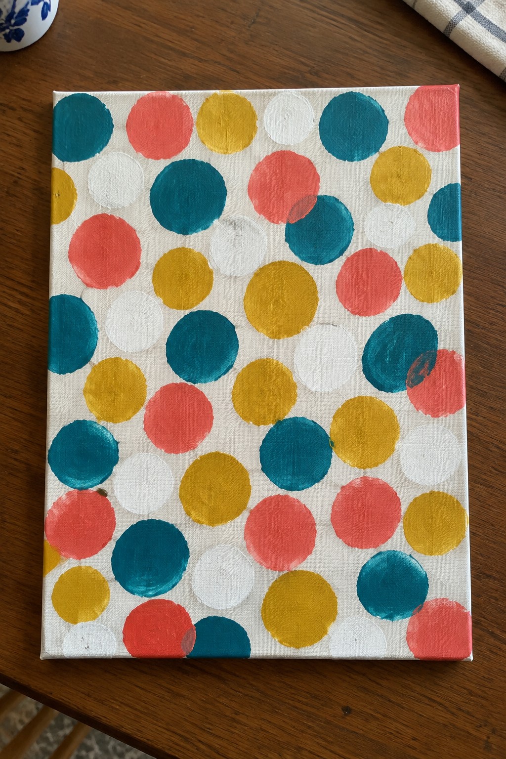 Colorful overlapping circles in teal, coral, yellow, and white on canvas.