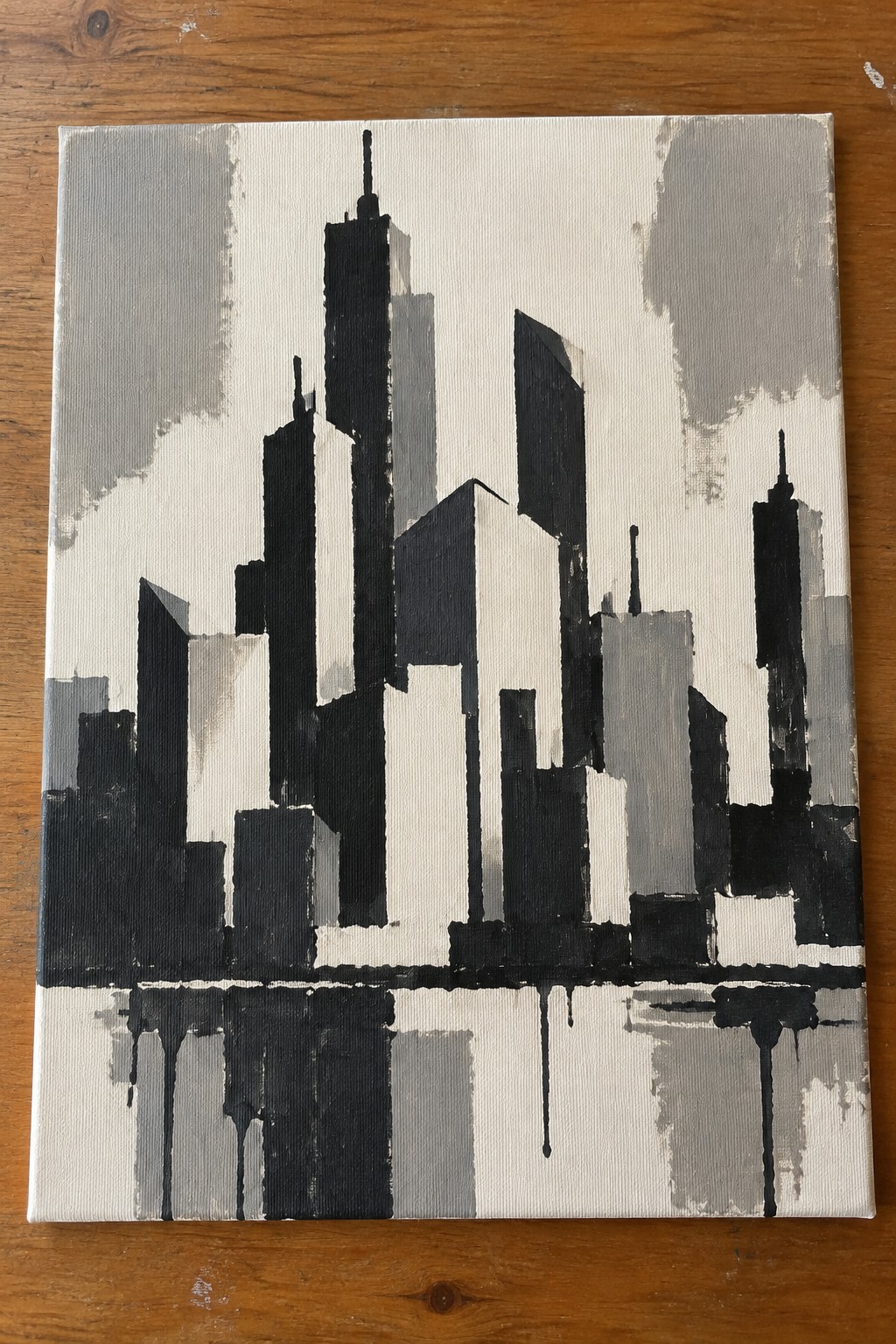 Abstract black and white city skyline painting with building reflections below