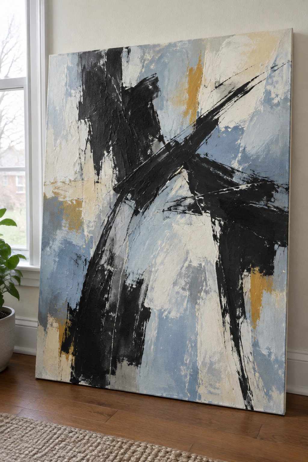 Large abstract painting with bold black, blue, and beige brushstrokes beside window