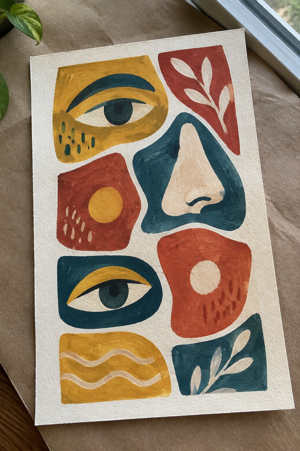 Abstract watercolor with stylized eyes, nose, geometric shapes, leaves, and waves in warm tones.