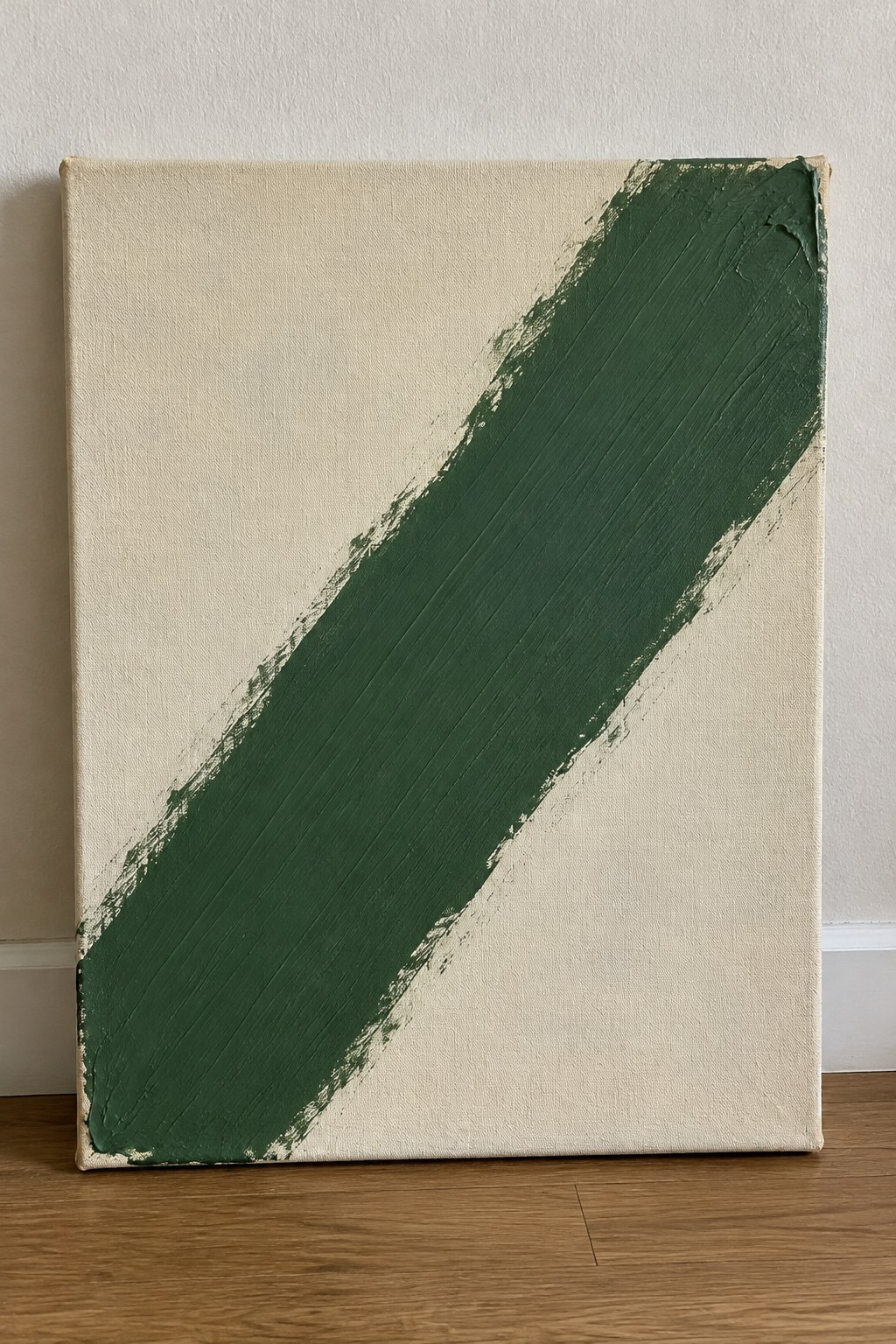 Abstract canvas with thick diagonal green brushstroke on off-white background.