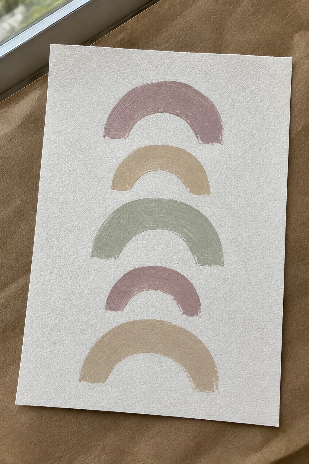 White paper with five stacked muted-tone arches in dusty rose, tan, and sage green