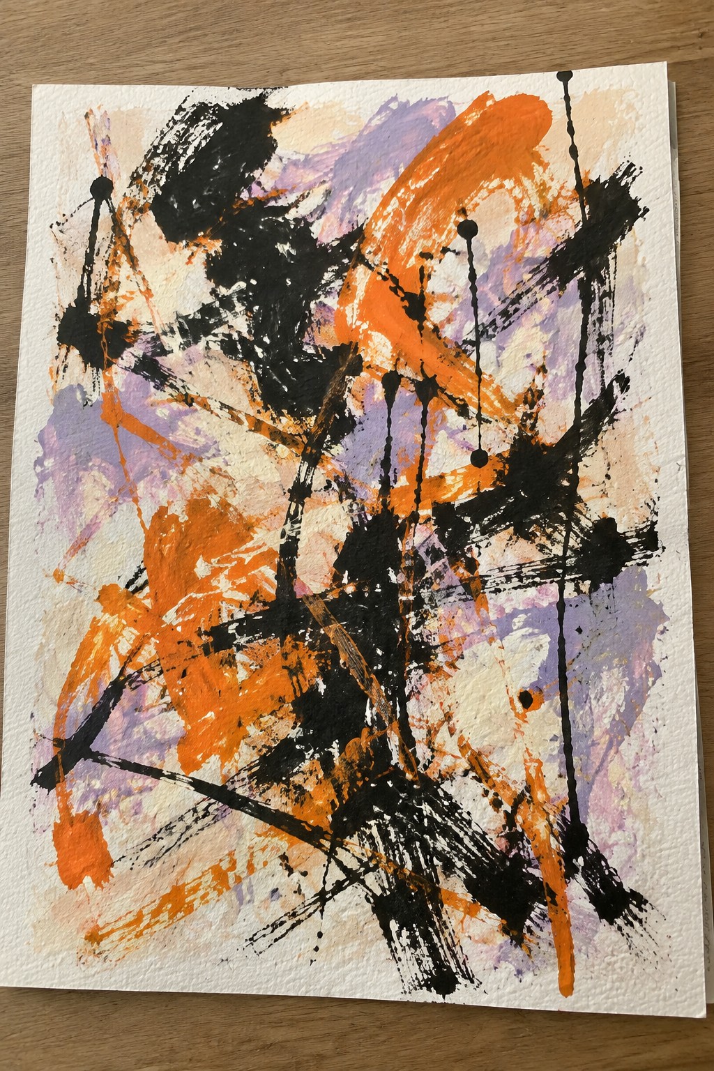 Abstract painting with bold orange, black, and purple brushstrokes and drips on white paper.