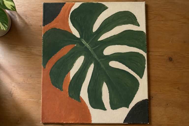 Green monstera leaf painting on orange and cream canvas with black strokes
