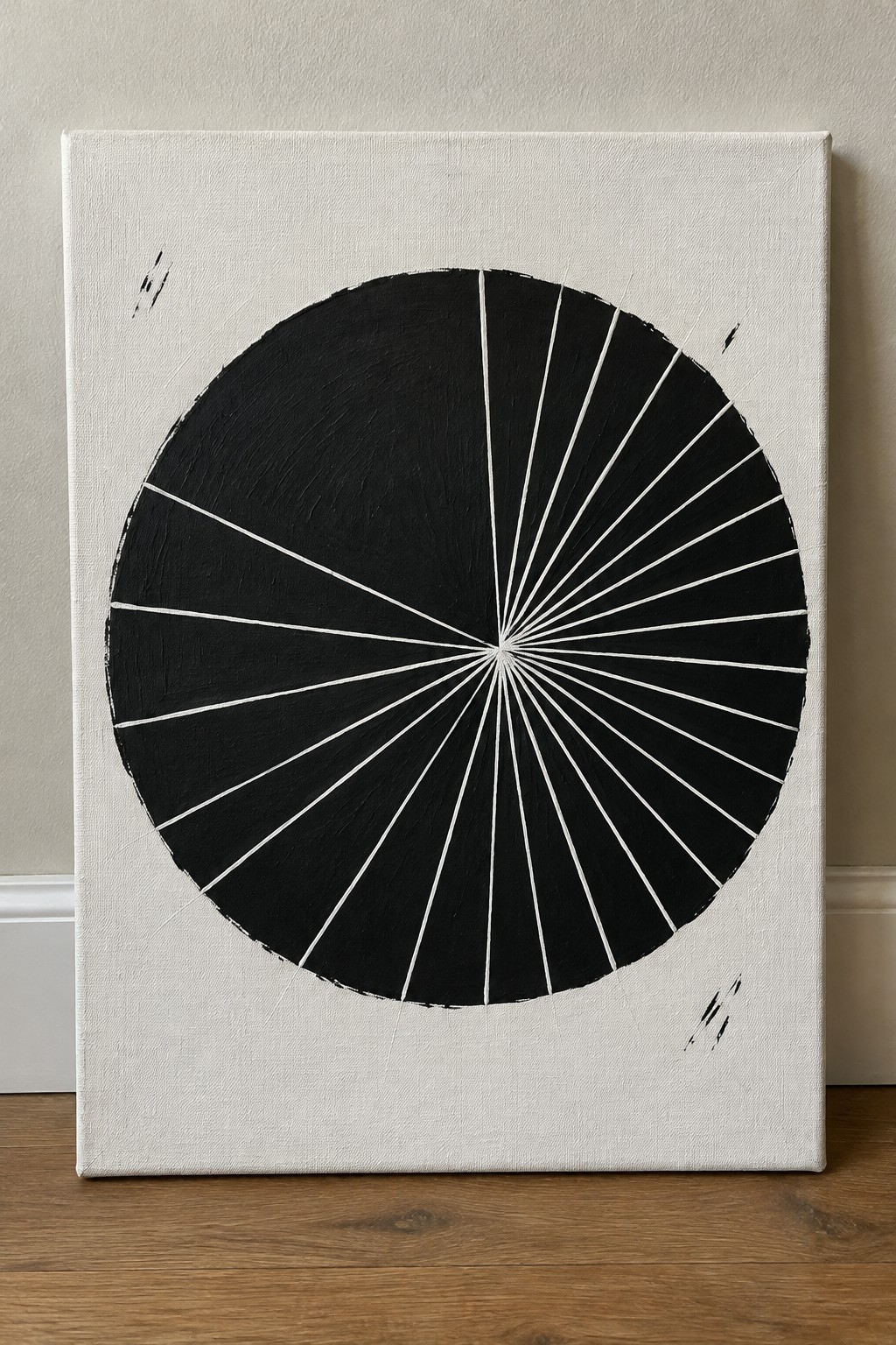 Abstract black circle with white radial lines on white canvas against wall