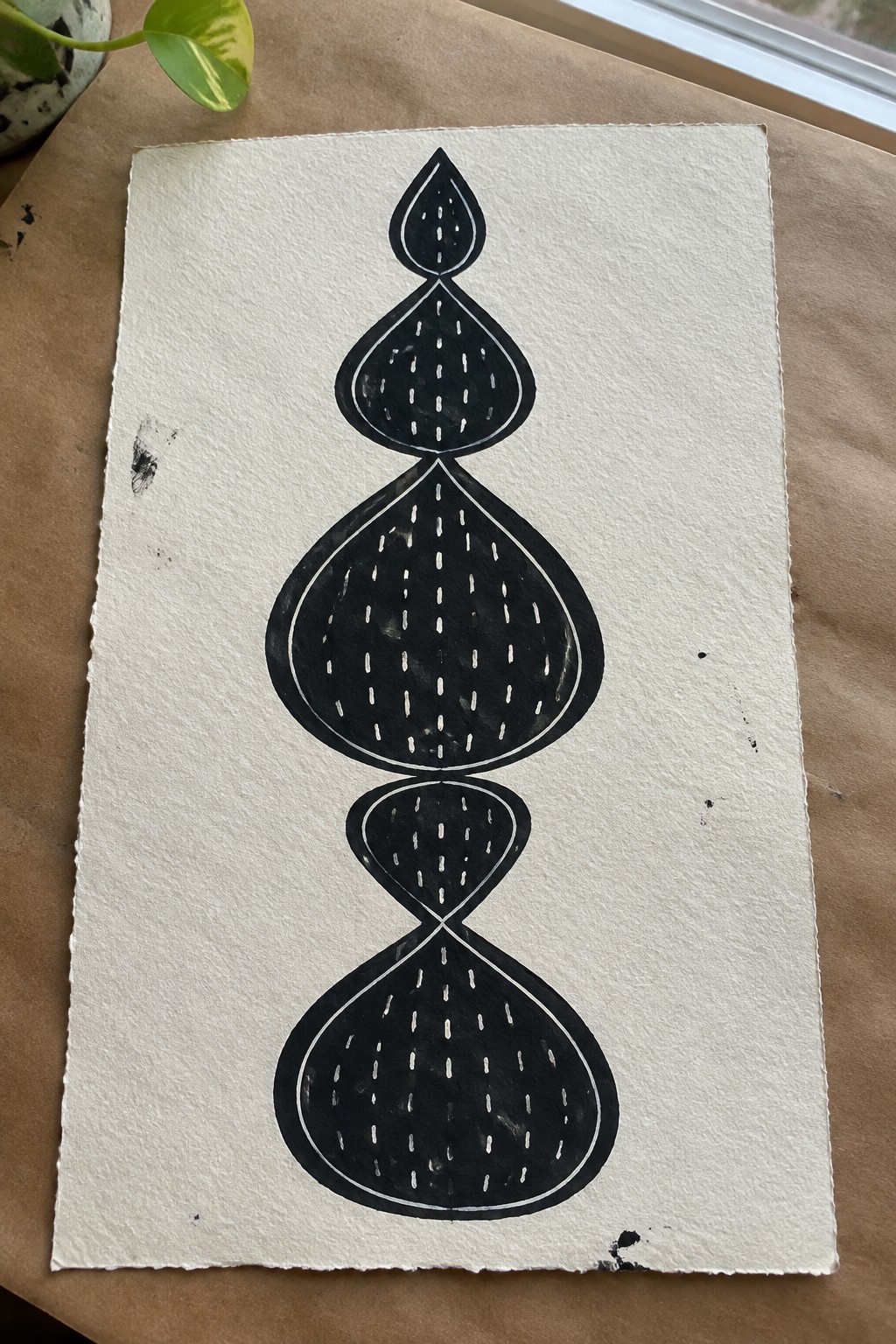 Bold black abstract drawing of stacked teardrop shapes with white dashed lines.