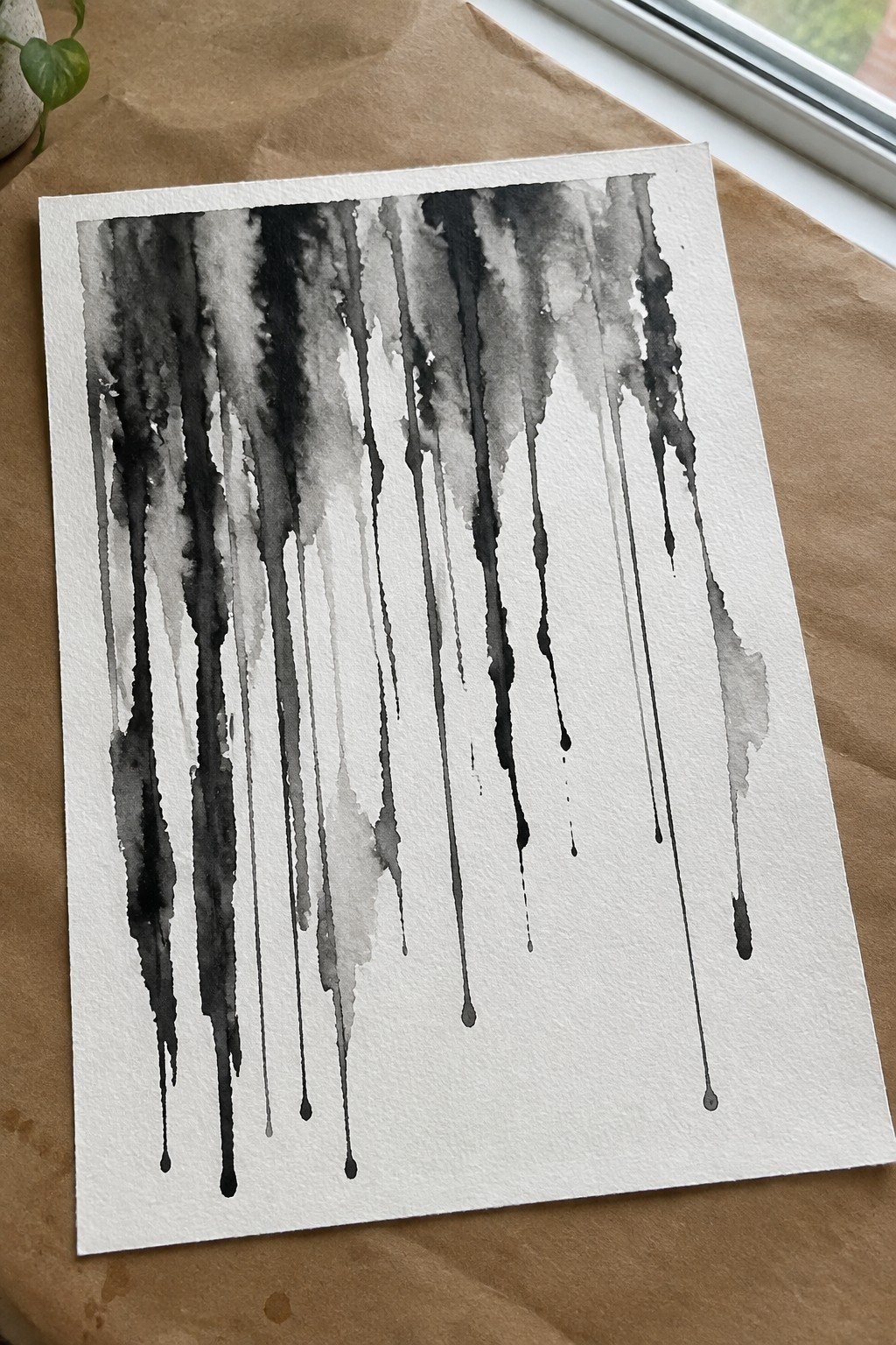 Abstract watercolor with vertical black and gray drips on white paper