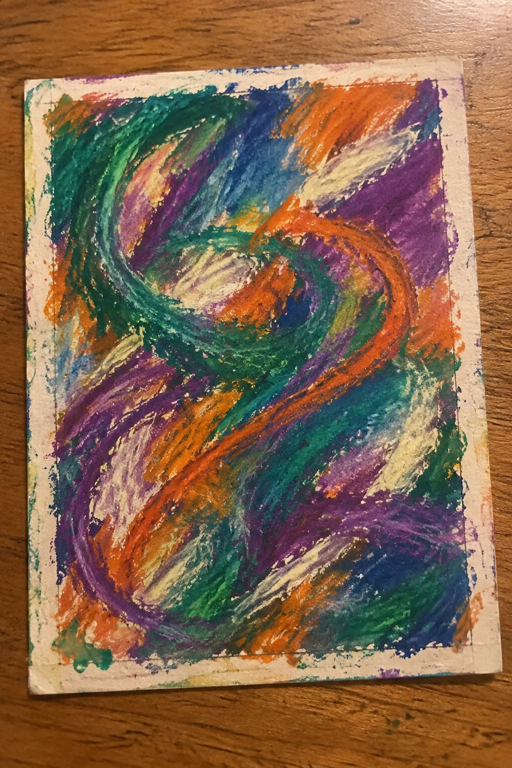 Vibrant abstract drawing with swirling green, orange, purple, and blue strokes on paper.