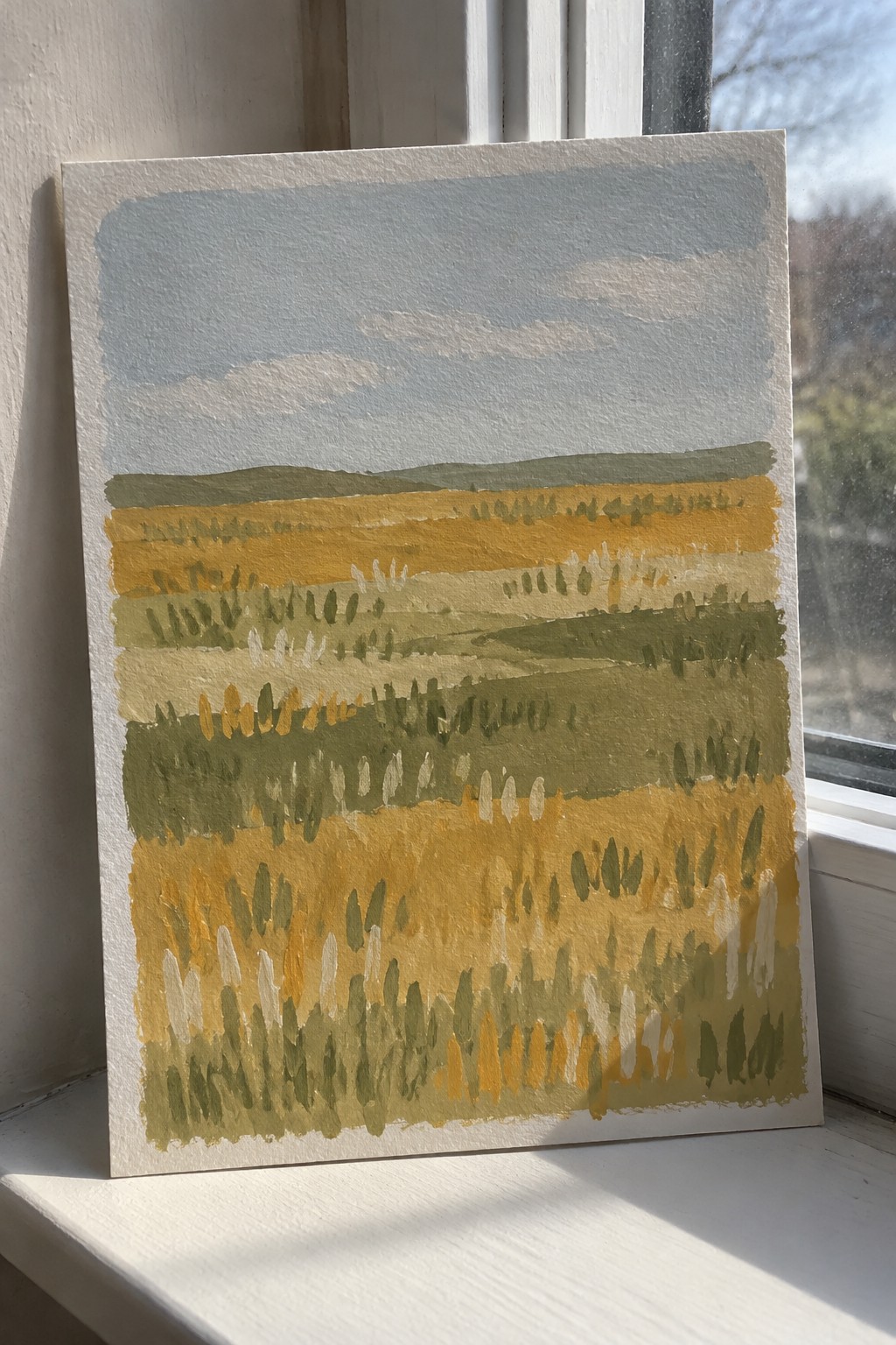 Abstract landscape painting with layered yellow, green, and blue fields under a pale sky.
