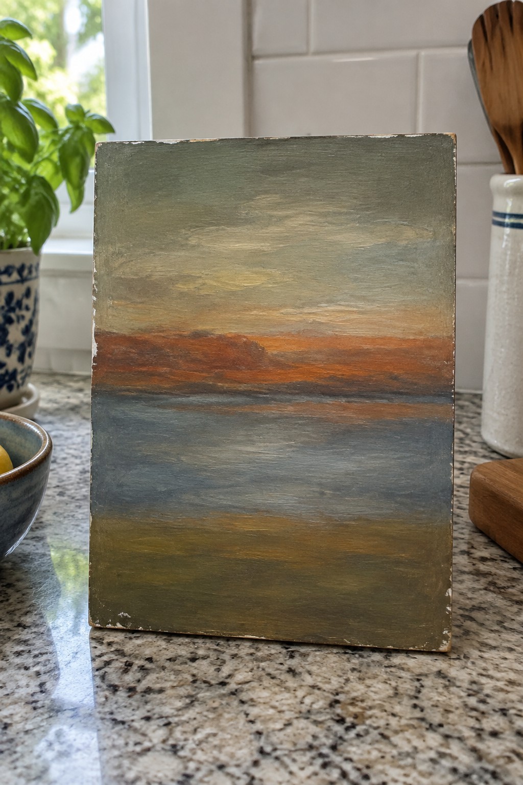 Abstract painting with horizontal bands of green, orange, blue, and brown on kitchen counter.