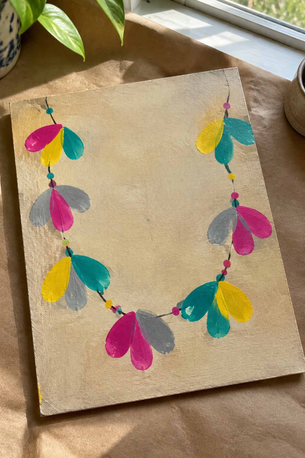 Abstract painting of vibrant garland with pink, yellow, teal shapes on beige canvas.