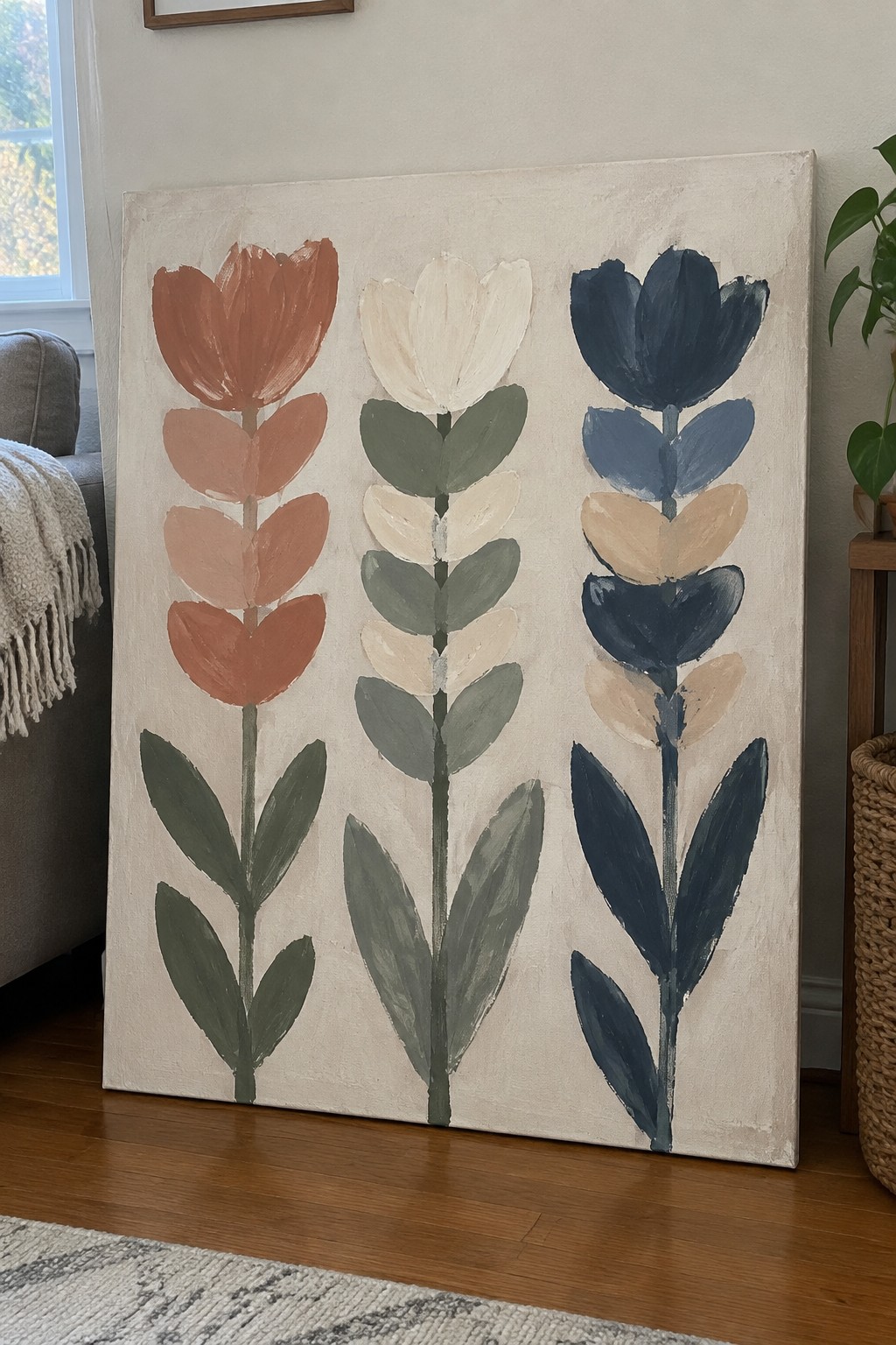 Abstract painting of three stylized tulips in rust, white, and navy on canvas