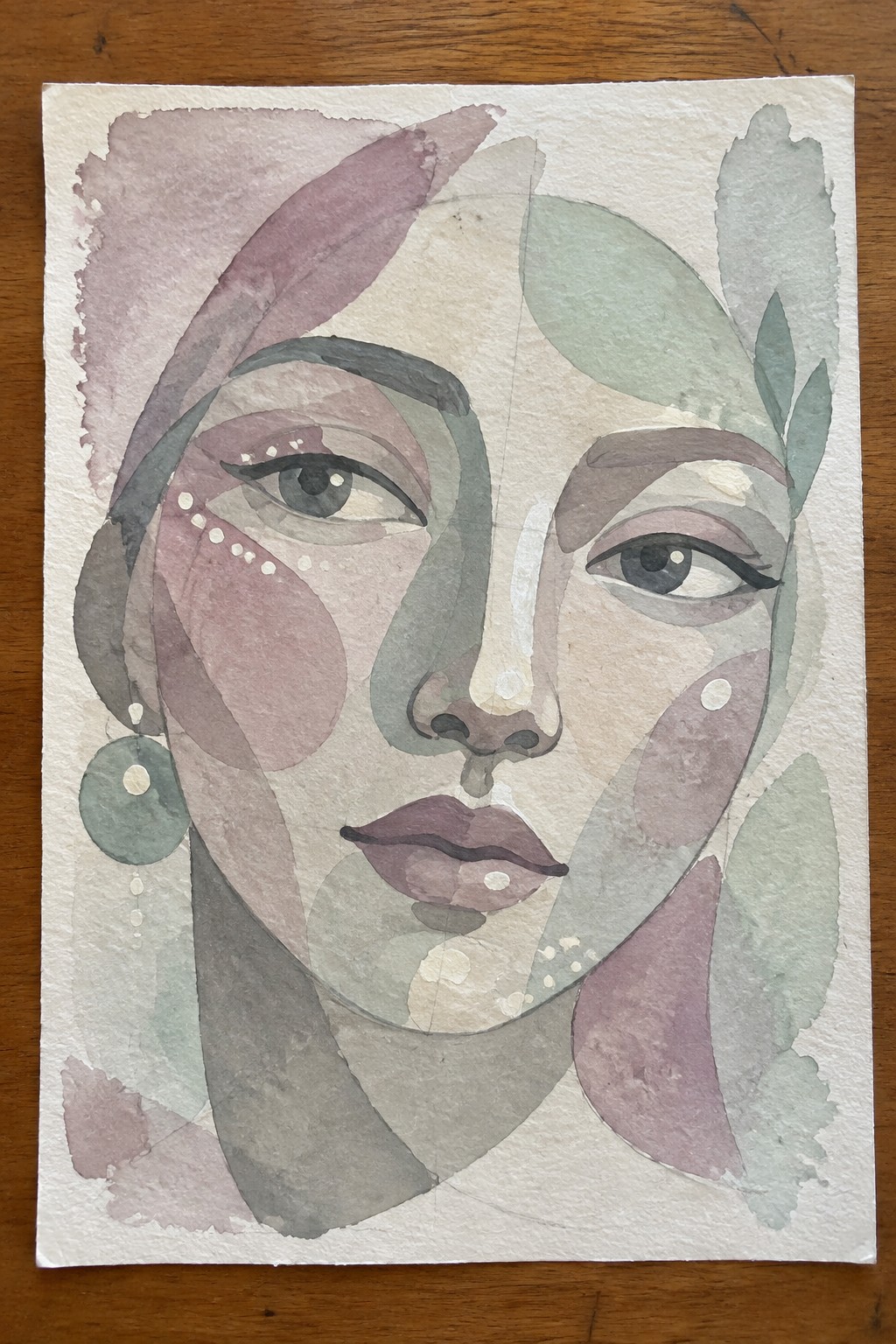 Abstract watercolor portrait of a woman with geometric pink and green shapes and dangling earring.