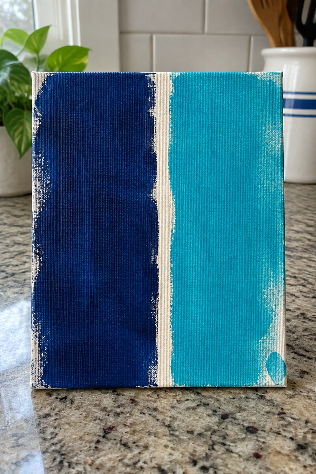 Abstract canvas painting split vertically into navy blue and turquoise sections with white stripe