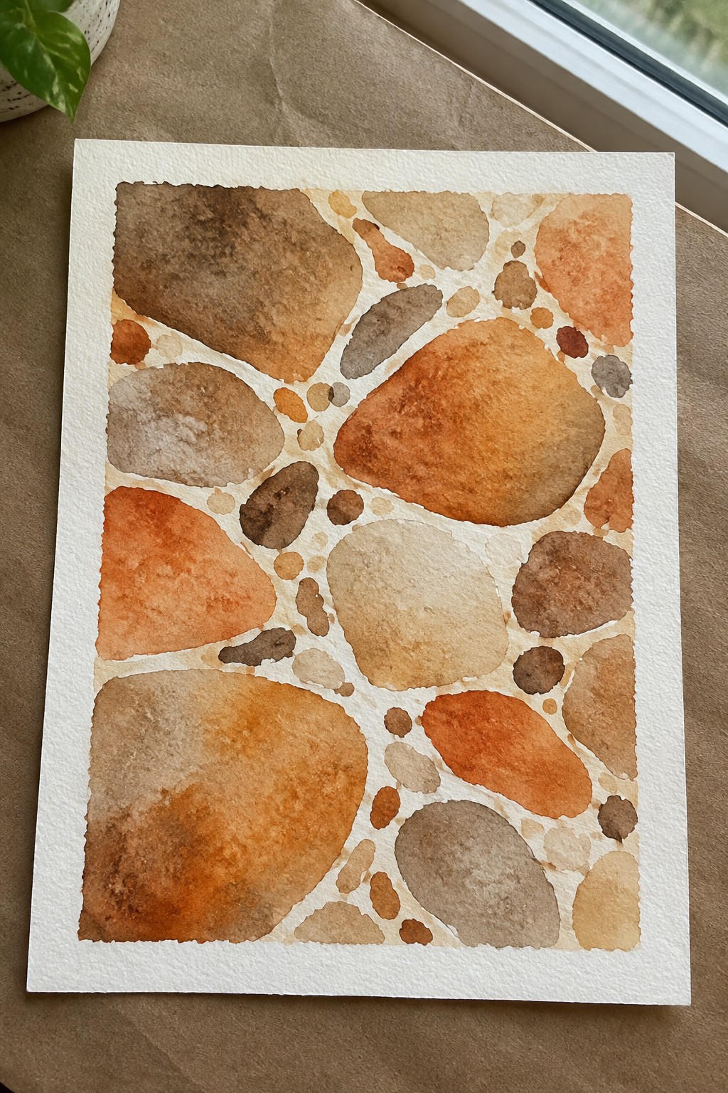 Abstract watercolor of pebble-like shapes in earthy brown and orange tones