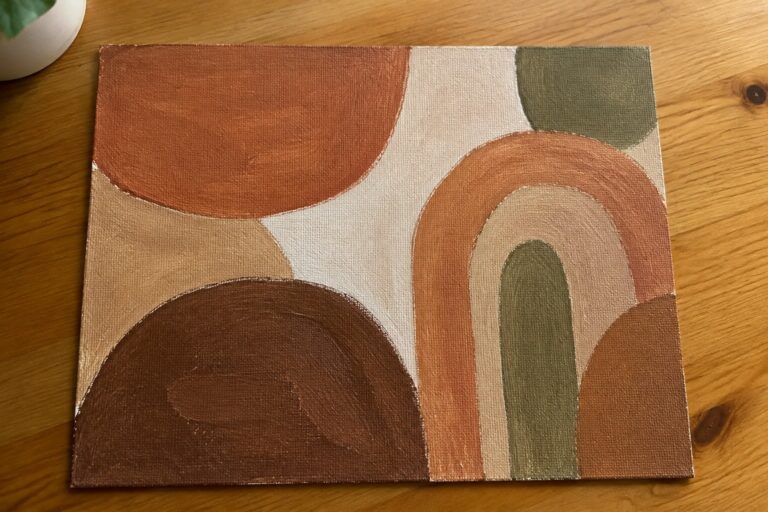 22 Earthy Abstract Art in Brown, Terracotta, and Beige Abstract painting with earthy arches and circles in terracotta, brown, and green on wood table