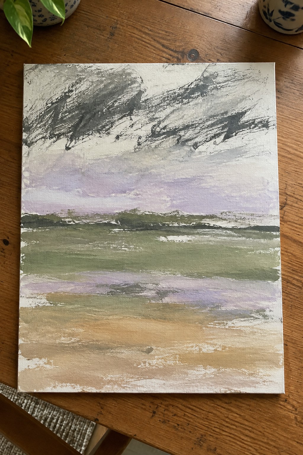 Abstract landscape painting with stormy gray sky over green fields and beige foreground