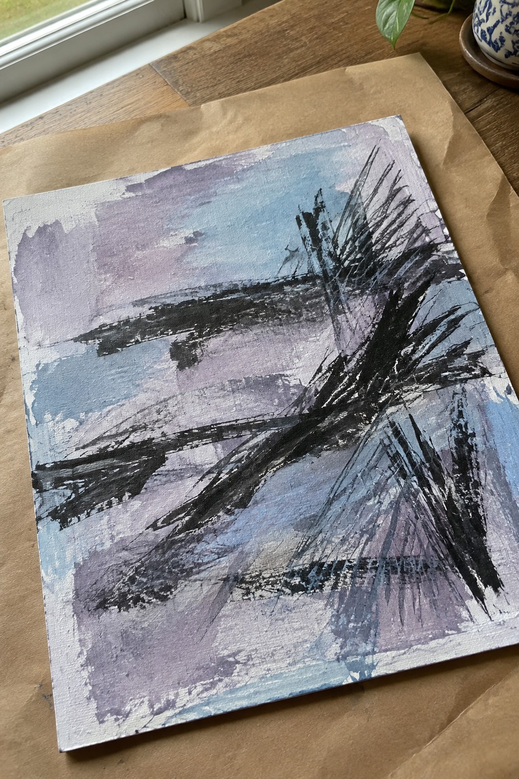 Square abstract canvas with bold black brushstrokes over blended blue and purple washes.