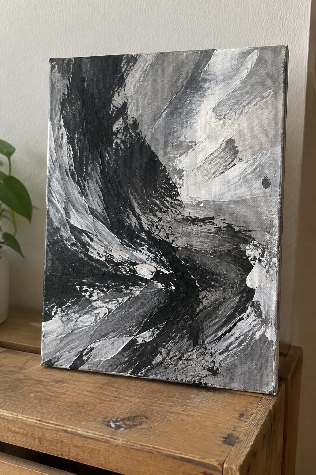 Abstract black and white painting with bold brushstrokes on wooden crate