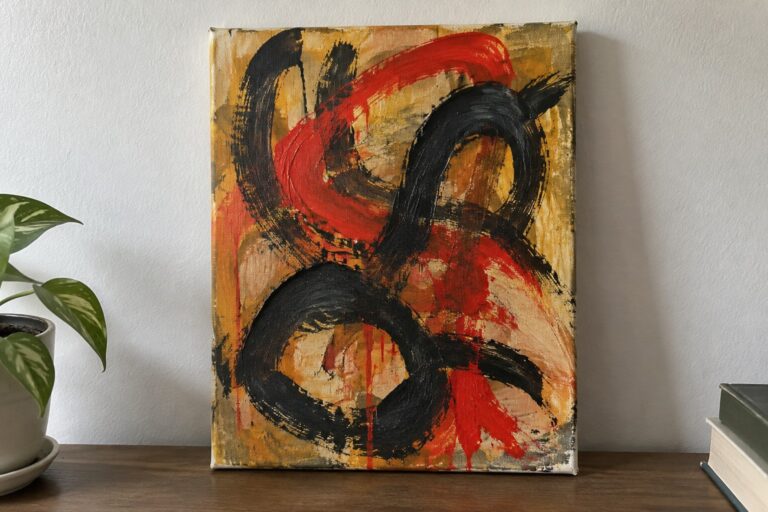 Abstract painting with bold red and black strokes on orange canvas beside plant