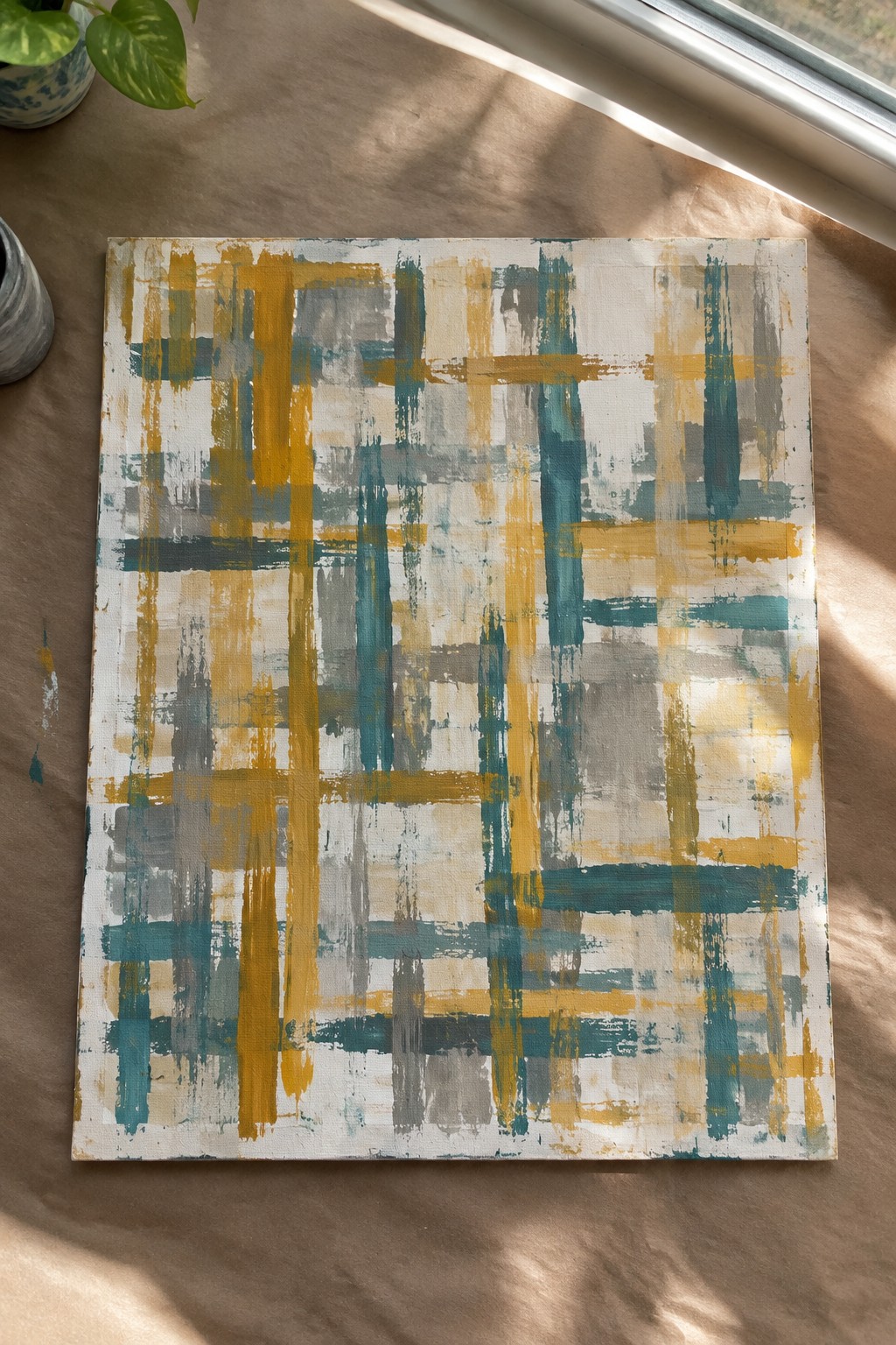 Abstract painting with intersecting yellow, teal, and gray brushstrokes on canvas.