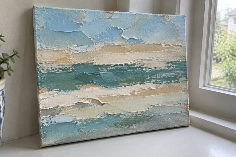 Textured abstract seascape in blues, teals, and beiges on white windowsill