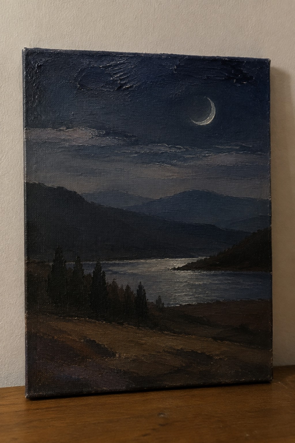 Oil painting of crescent moon above dark mountains and reflective lake at night.