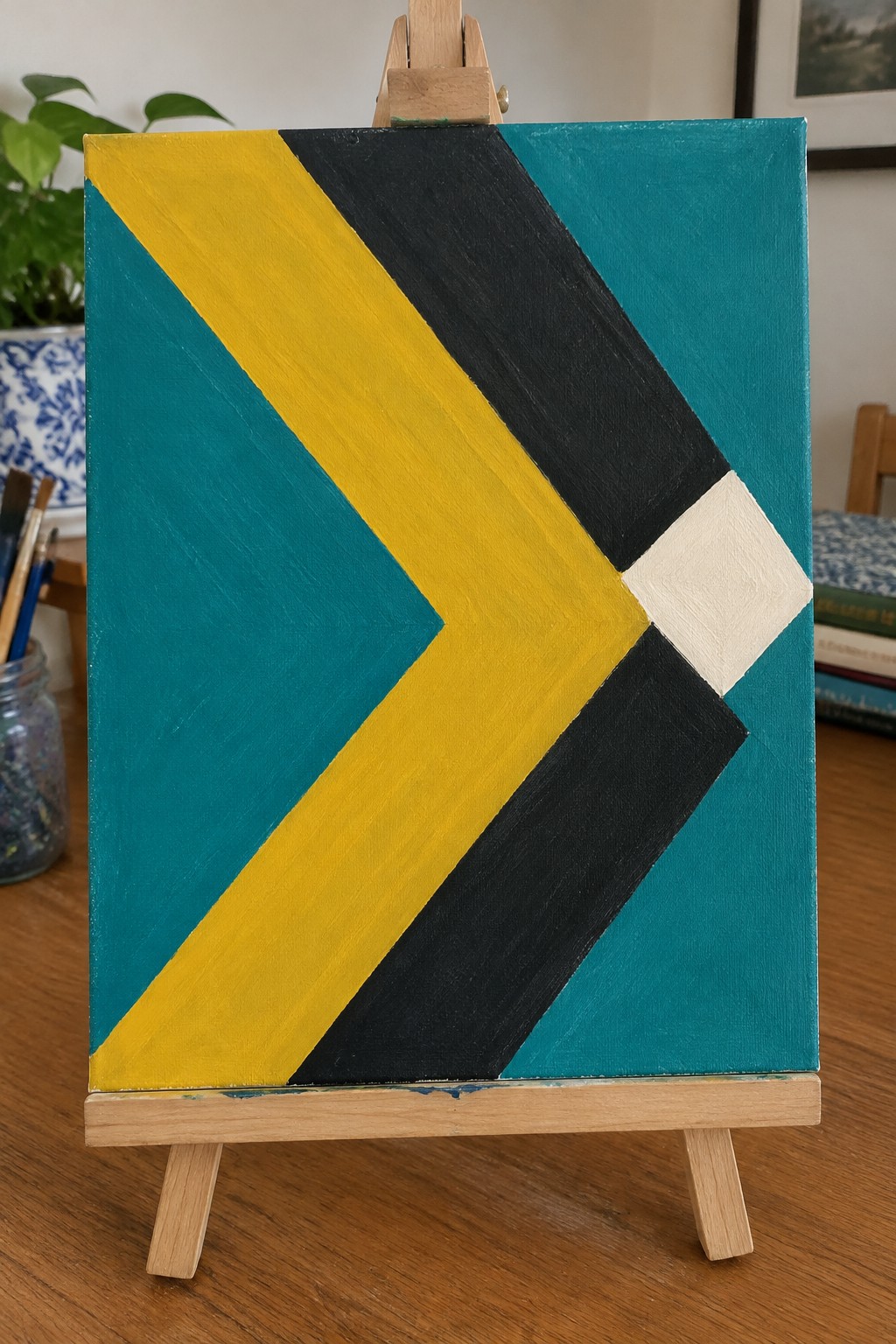Abstract geometric painting with teal yellow black bands and white square on easel.