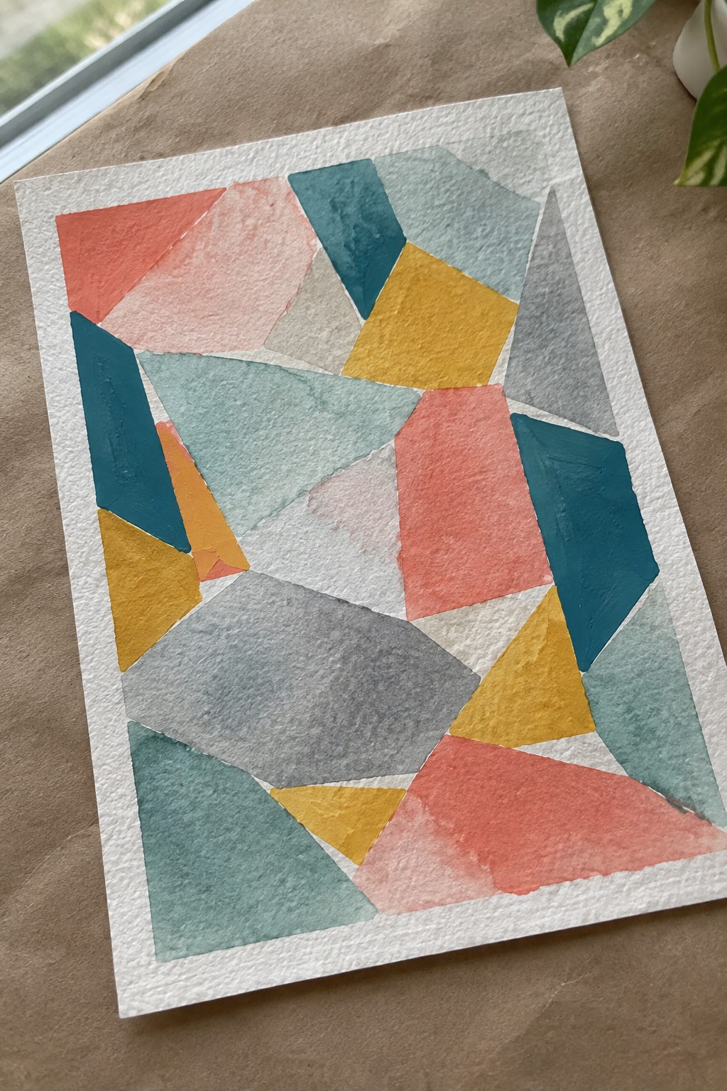 Abstract geometric watercolor with coral, teal, yellow, gray polygons on white paper.