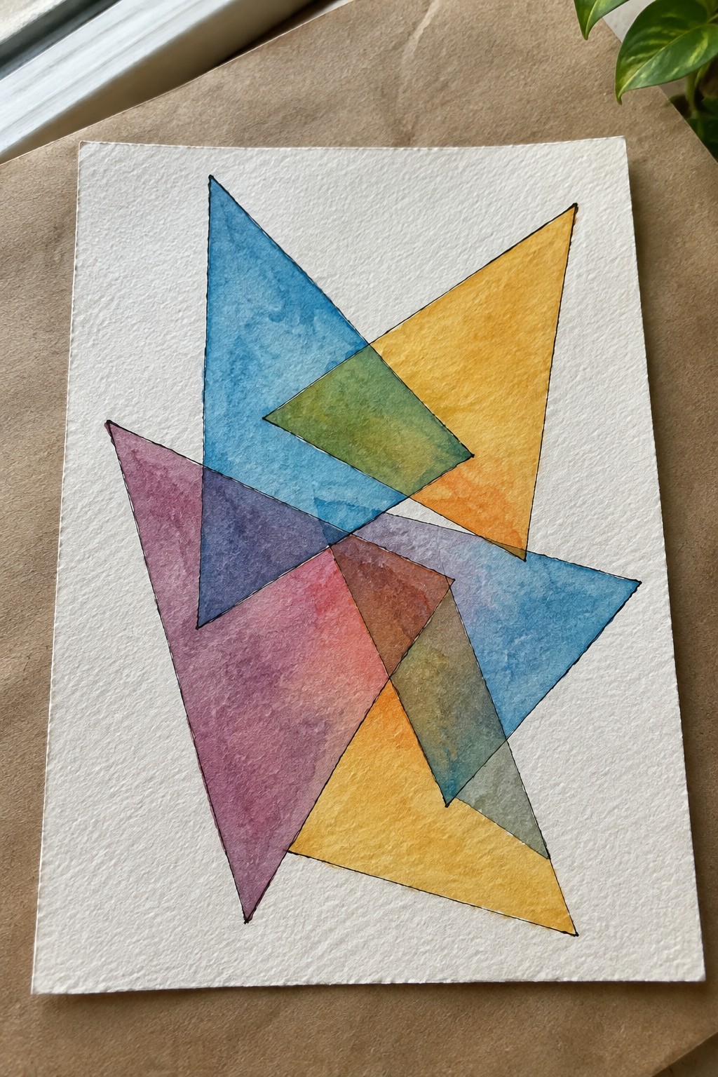 Abstract watercolor artwork of overlapping multicolored triangles in blue, yellow, purple, and green