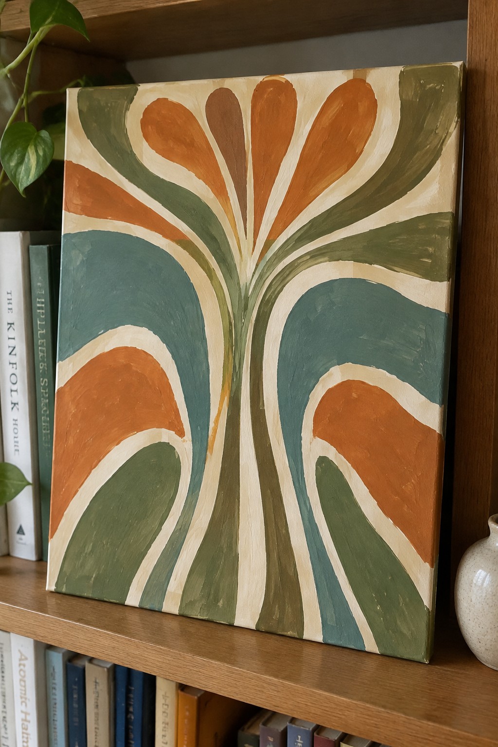 Abstract retro painting with teal, orange, and green curved shapes on bookshelf